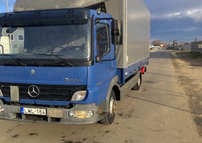 Ponyvás platós belföldi teherautó 1 tonnás emelőhátfallal szerelve.